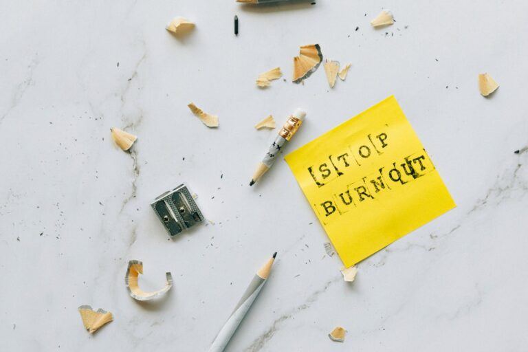 Pencil and shavings with 'Stop Burnout' note on marble surface convey stress relief concept.