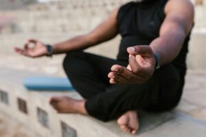 A man meditating and practicing yoga outdoors, focusing on mindfulness.