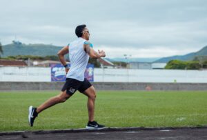 Man sprinting on outdoor track in Guadalajara de Buga, Colombia, showcasing intense athletic performance.
