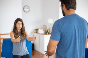 A couple engaging in a fitness routine at home, focused and determined in their living room setting.