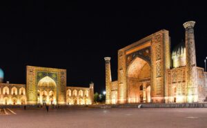 Illuminated architecture of Registan Square in Samarkand under the night sky.