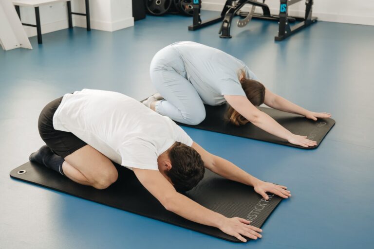 Adults practicing yoga poses in a Vilnius gym. Focus on health and flexibility.