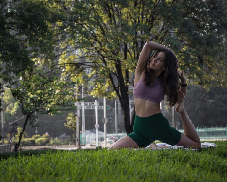 A young woman practices yoga in a lush park in Ciudad de México, surrounded by greenery.